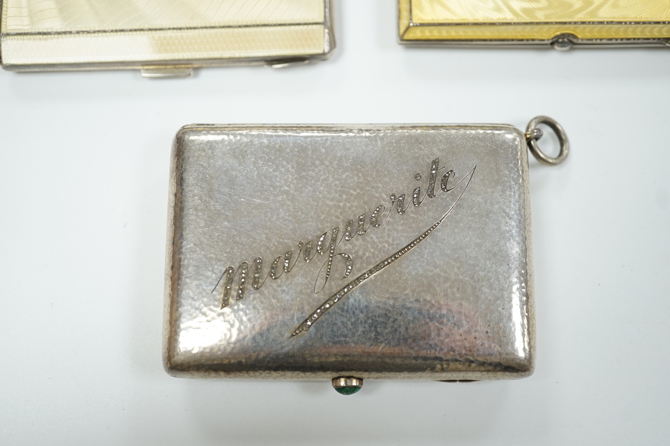 Two George V Art Deco silver and enamel cigarette cases, Birmingham, 1931 & 1932, largest 85mm (enamel a.f. on one) together with a German 800 standard white metal, cabochon emerald and rose cut diamond set compact/minau